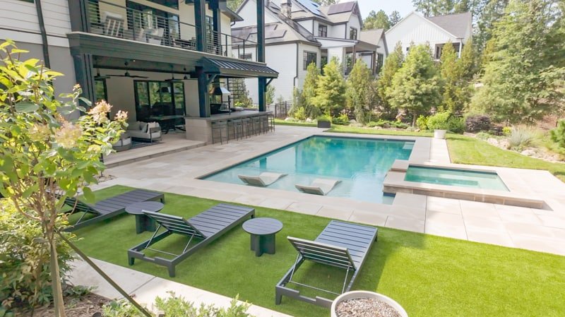 Pool, spa, lounge chairs, and covered outdoor living area at 241 Cape August Place