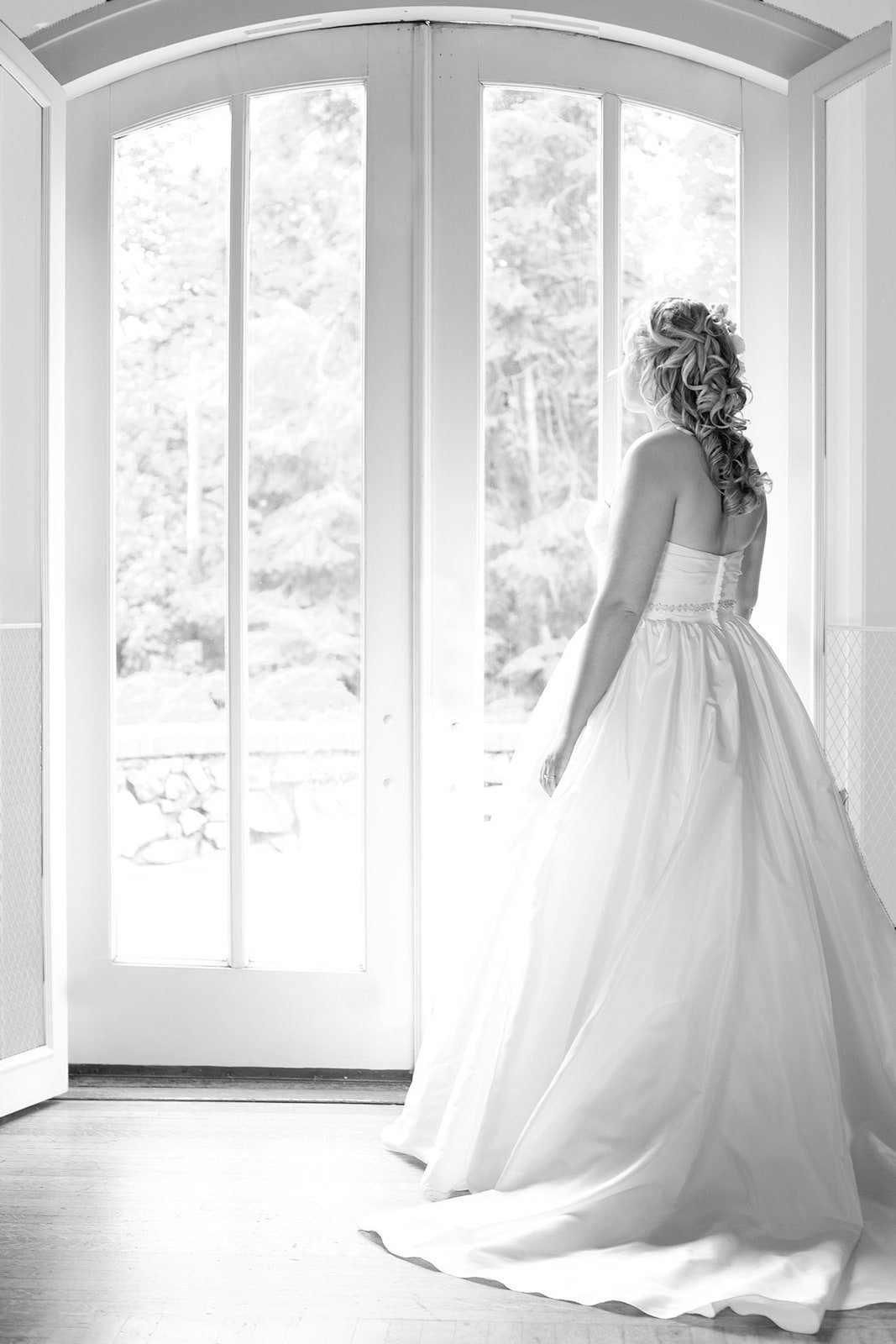 Black and white portrait of a bride beside a window